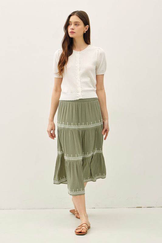 Lightweight pointelle short sleeve cardigan with scalloped edges and button front.