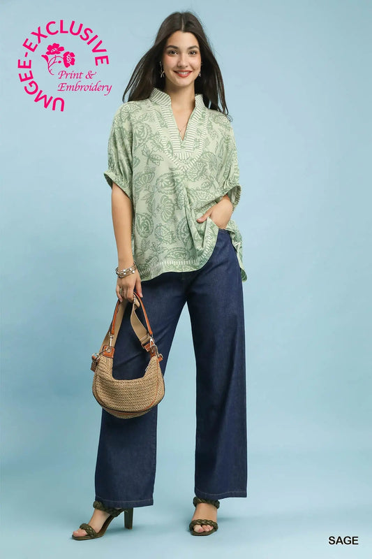 oversized botanical print tunic featuring contrast trim and relaxed dolman sleeves.