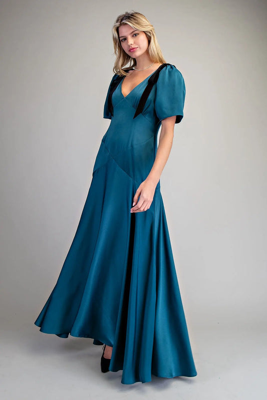 A romantic satin maxi dress with velvet bow tie sleeves, a plunging V-neckline, and a flowing A-line skirt.