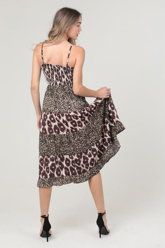 A bold mixed animal print midi dress with a twist-front bodice and striking waist cut-out.