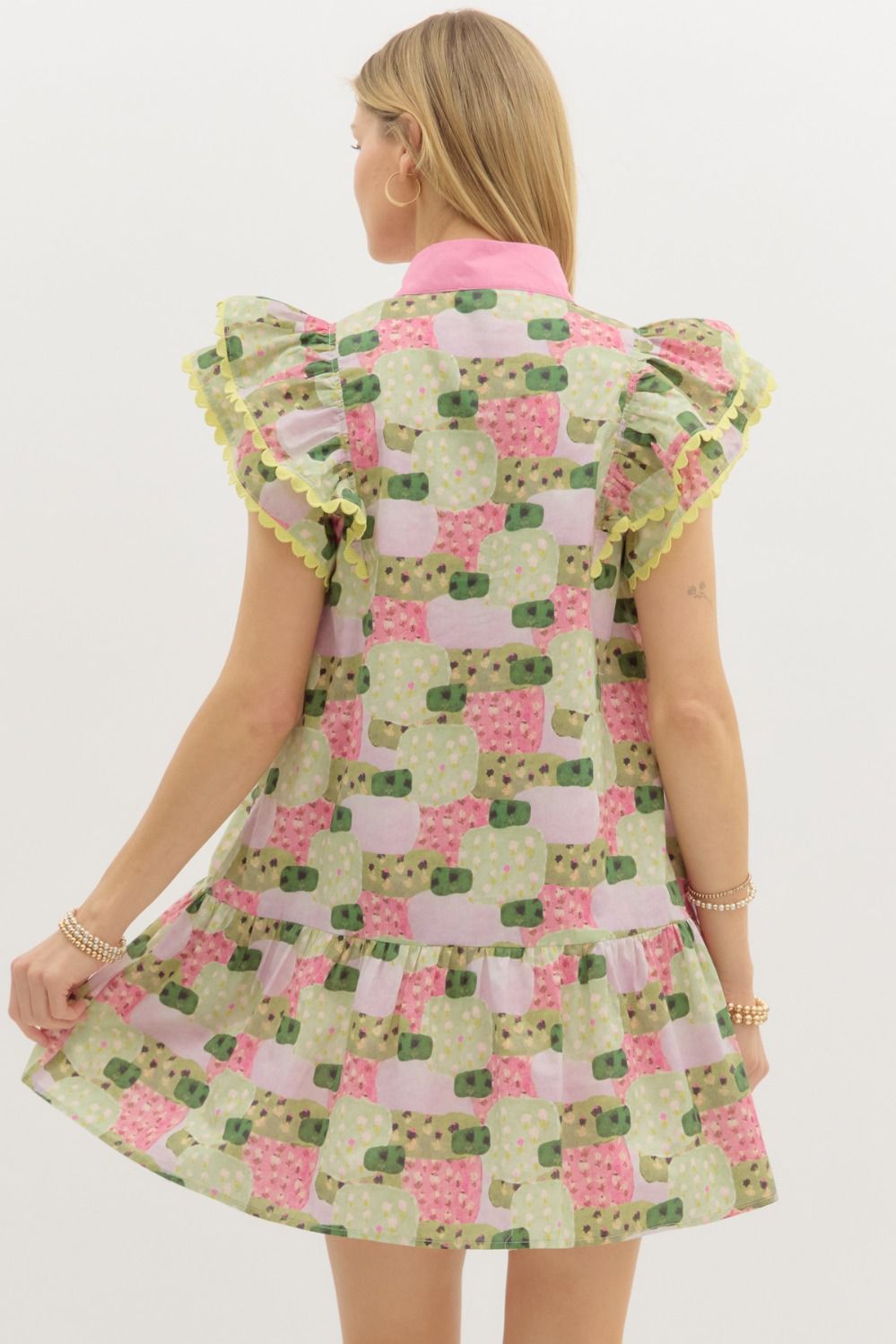 A breezy abstract print mini dress with flutter sleeves, contrast detailing, and tiered ruffle charm.