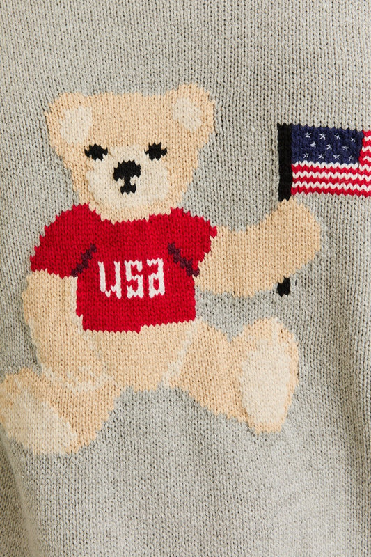 A cozy, cute, and patriotic sweater featuring an adorable teddy bear holding the USA flag—perfect for laid-back, stylish layering.