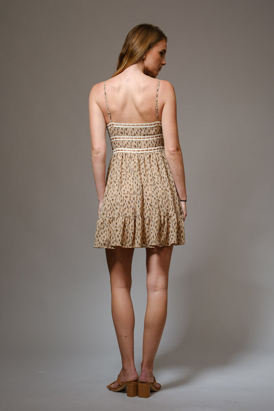 A flirty leopard print chiffon mini dress with lace tape accents and a front tie detail.