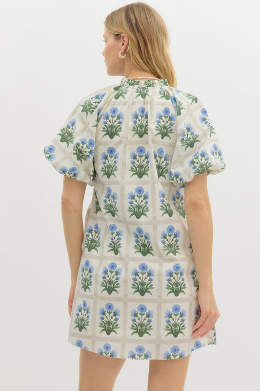 A floral mini dress with bubble sleeves, a ruffle-trimmed neckline, and breezy side pockets.