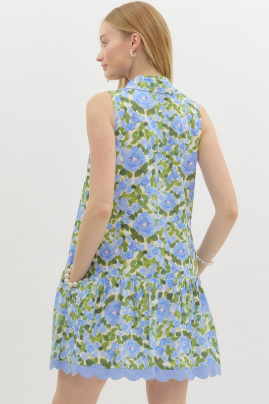 A floral sleeveless mini dress with a shirt collar, scalloped embroidery, and ruffle hem—playful, polished, and perfect for warm weather.