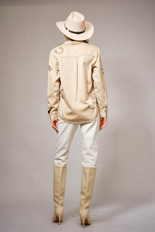 A garment-washed chambray shirt with western embroidery and classic snap buttons.