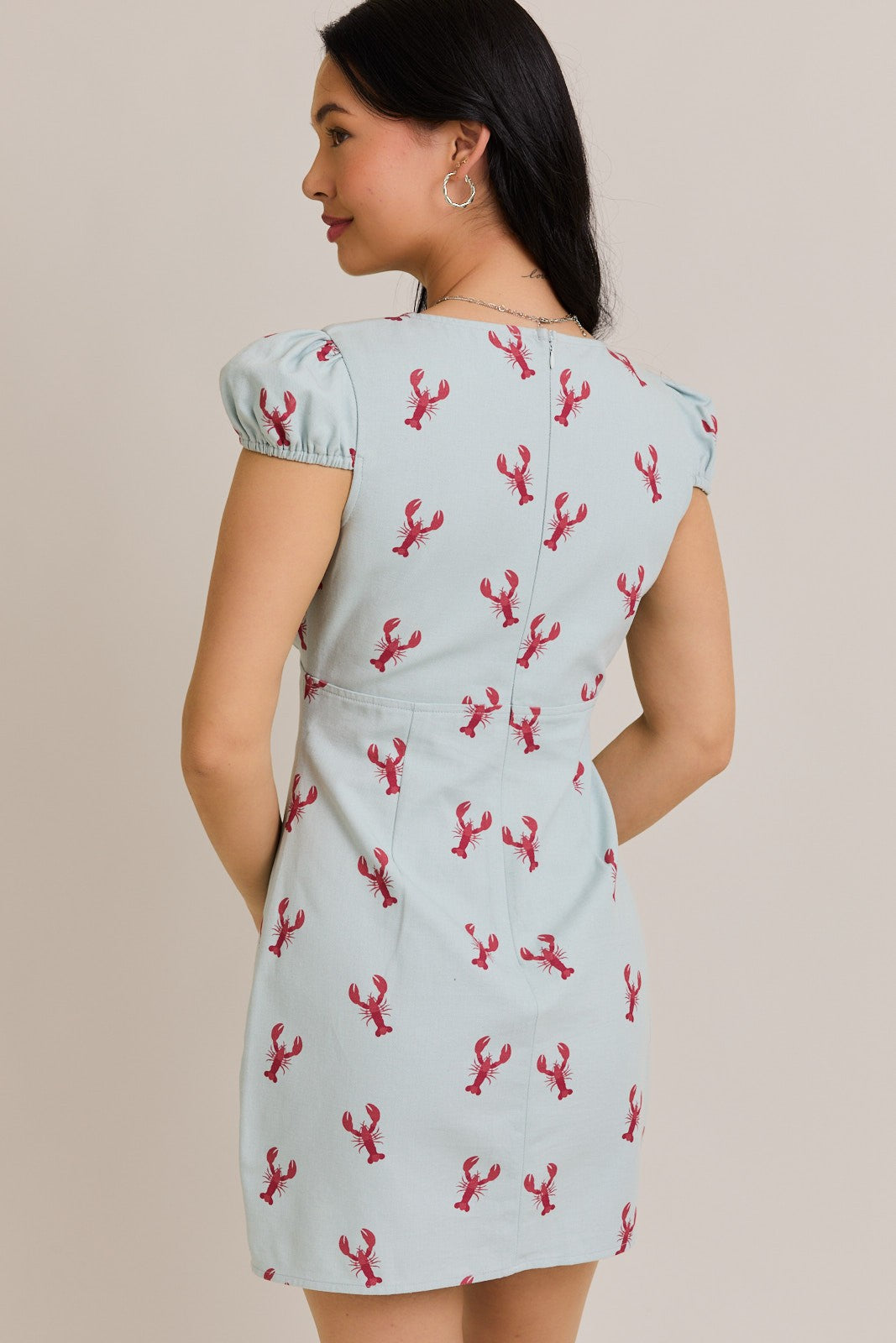 A playful cap sleeve mini dress with a lobster graphic and flattering V-neckline—perfect for fun-in-the-sun style.