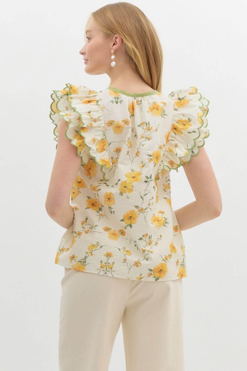 A romantic floral pullover top with sweet bow detail and layered scallop-embroidered ruffles.