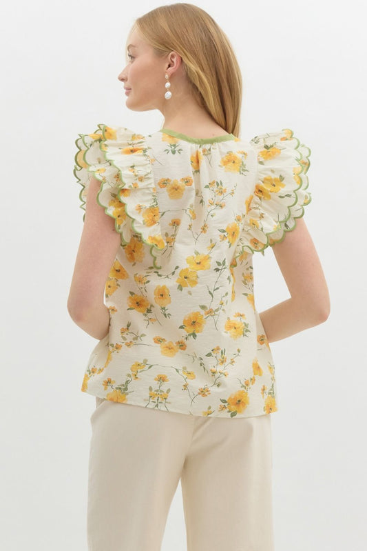 A romantic floral pullover top with sweet bow detail and layered scallop-embroidered ruffles.
