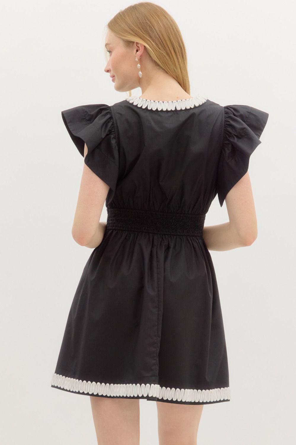 A romantic flutter sleeve mini dress with elegant applique detail and a flattering smocked back.