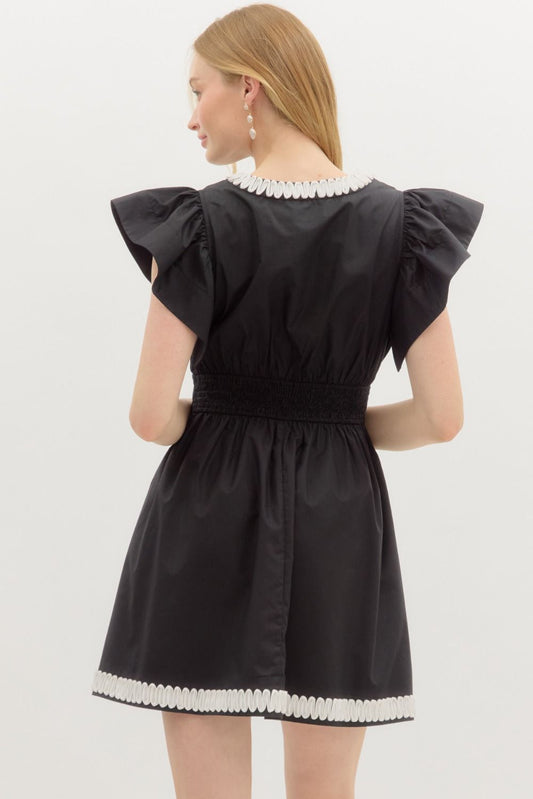 A romantic flutter sleeve mini dress with elegant applique detail and a flattering smocked back.
