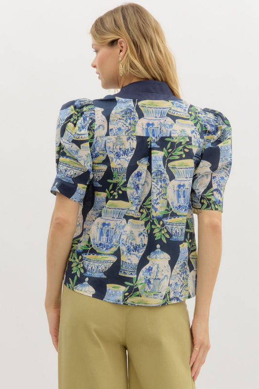 A whimsical garden landscape print top with puff sleeves and contrast placket detailing.