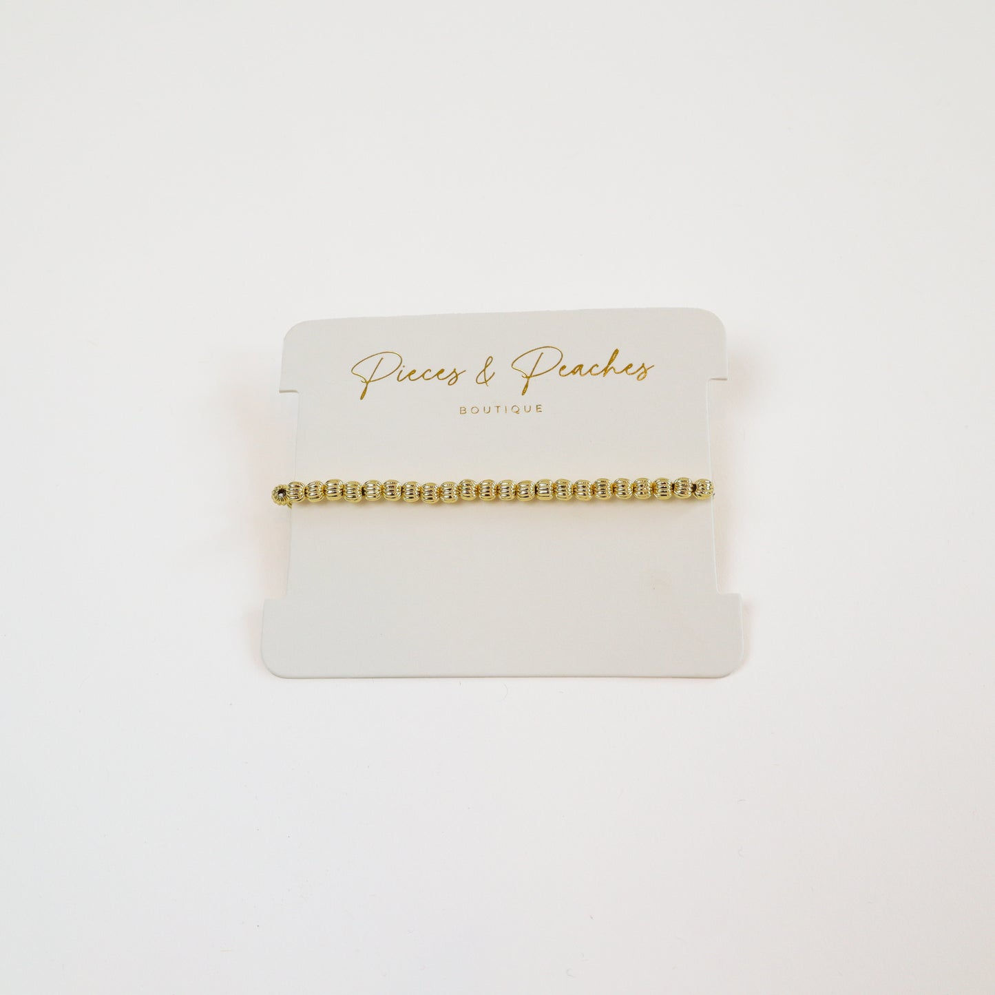 14k gold-filled textured beaded bracelet on wrist" | "Minimalist gold bracelet on white background