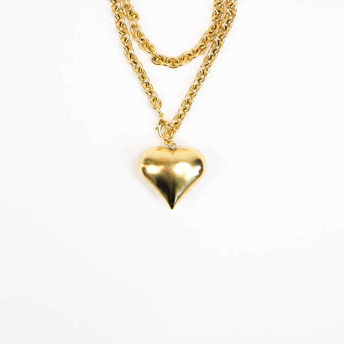 A handcrafted 22K gold-plated statement necklace featuring a bold, oversized heart pendant suspended from a chunky gold chain, exuding elegance and confidence.