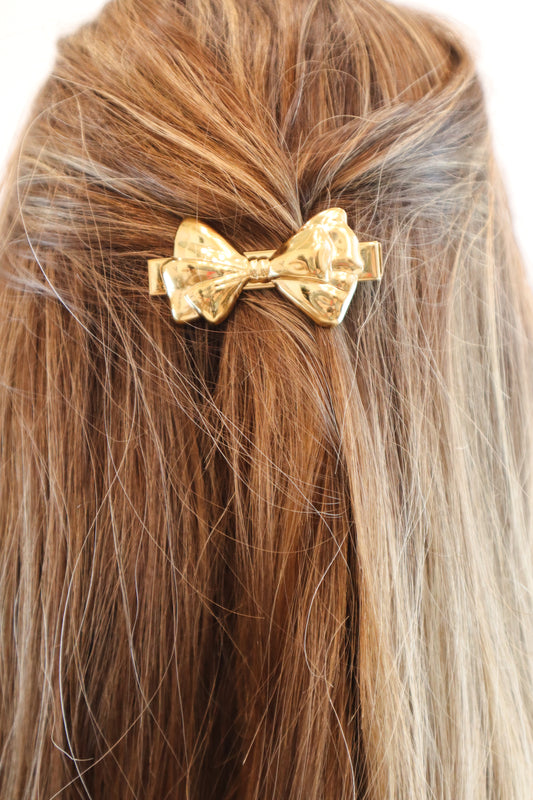 Elegant gold bow hair clip with a polished finish