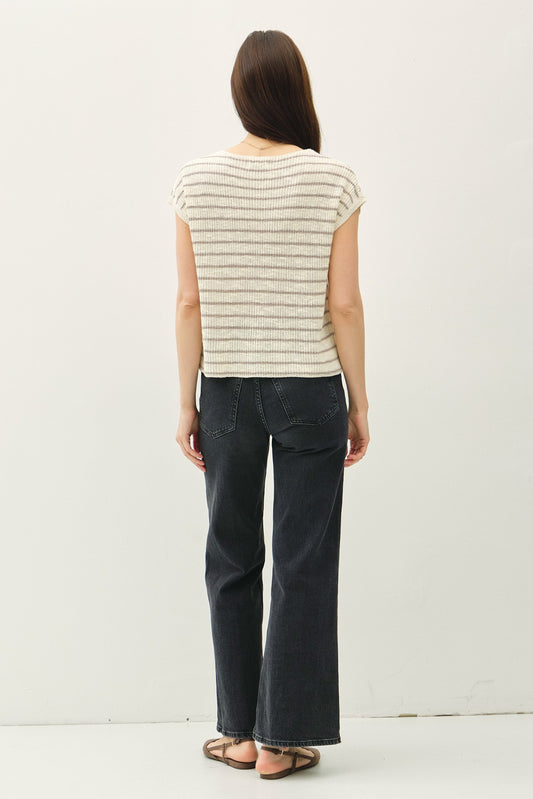 Women's beige and brown striped knit top with cap sleeves, a front pocket detail, and a relaxed fit, paired with black wide-leg jeans for a modern casual look.