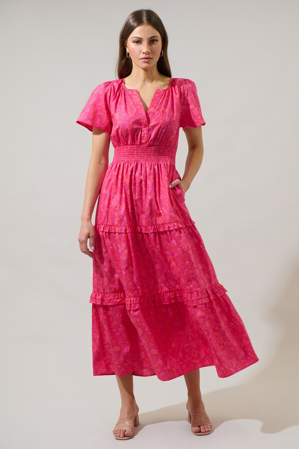 Vibrant pink floral midi dress with a smocked waist, flutter sleeves, and a flowy tiered skirt, perfect for date nights and special occasions.