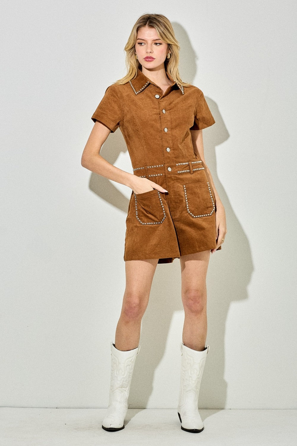 Edgy studded denim romper with structured details and utility-inspired accents.