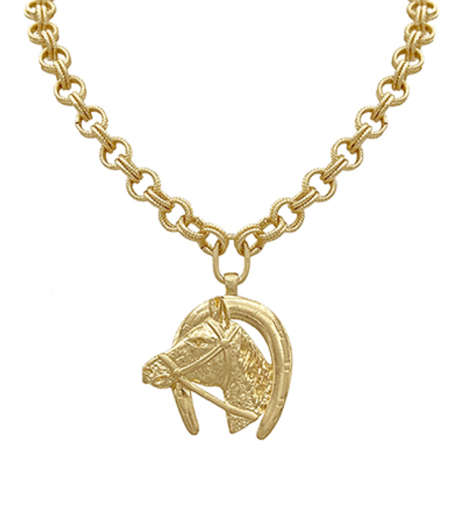 A majestic gold-toned necklace featuring a substantial, textured rolo-style chain, suspending a large circular pendant with a detailed horse head in a bridle, set within a horseshoe shape. The entire piece is gold-toned.