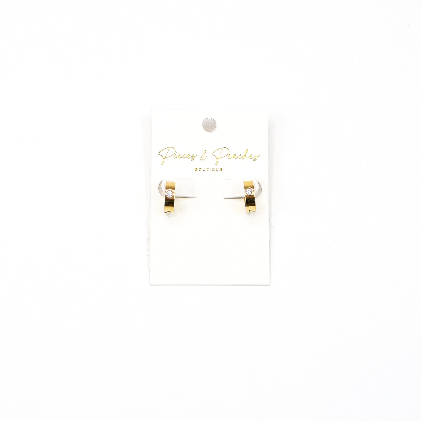 “Gold huggie hoop earrings with a single cubic zirconia stone, featuring a minimalist and modern design for everyday elegance.