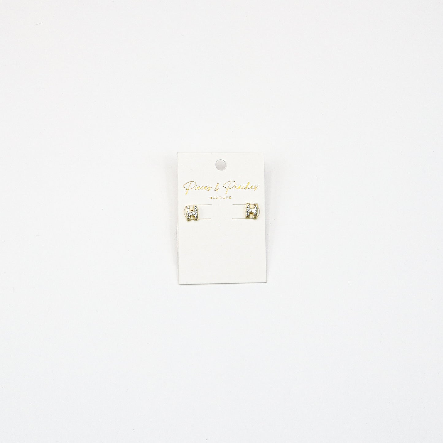 Gold H-shaped stud earrings with cubic zirconia accents, featuring a minimalist yet elegant design for everyday wear