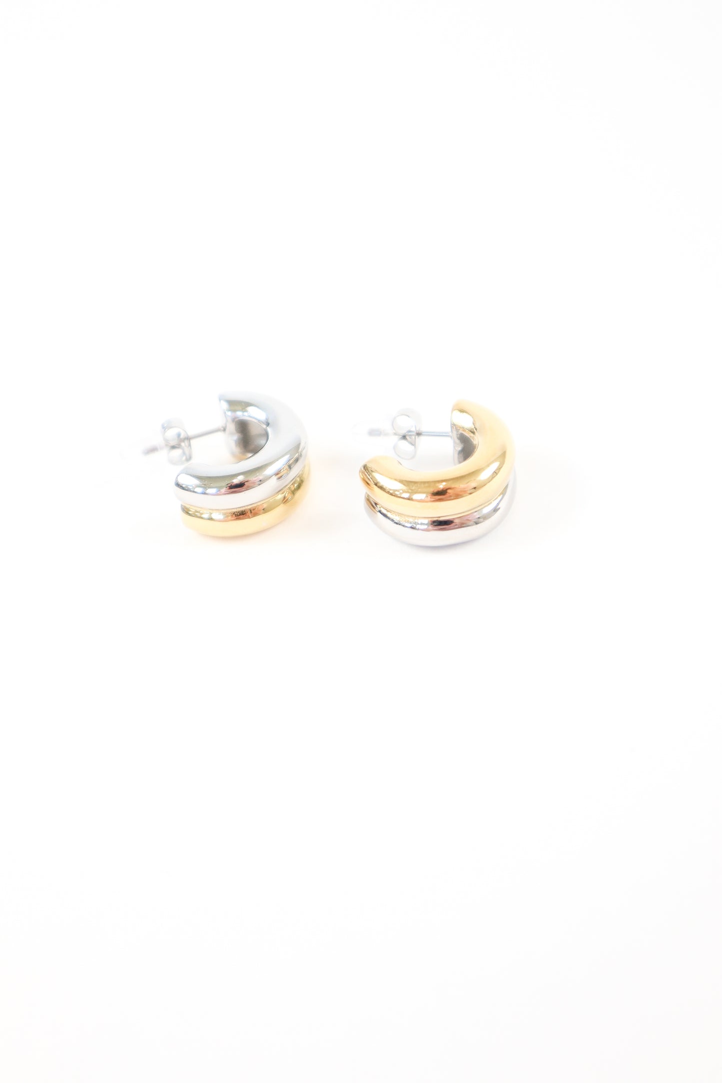 Two-tone chunky dome huggie earrings in polished gold and silver with post back closure