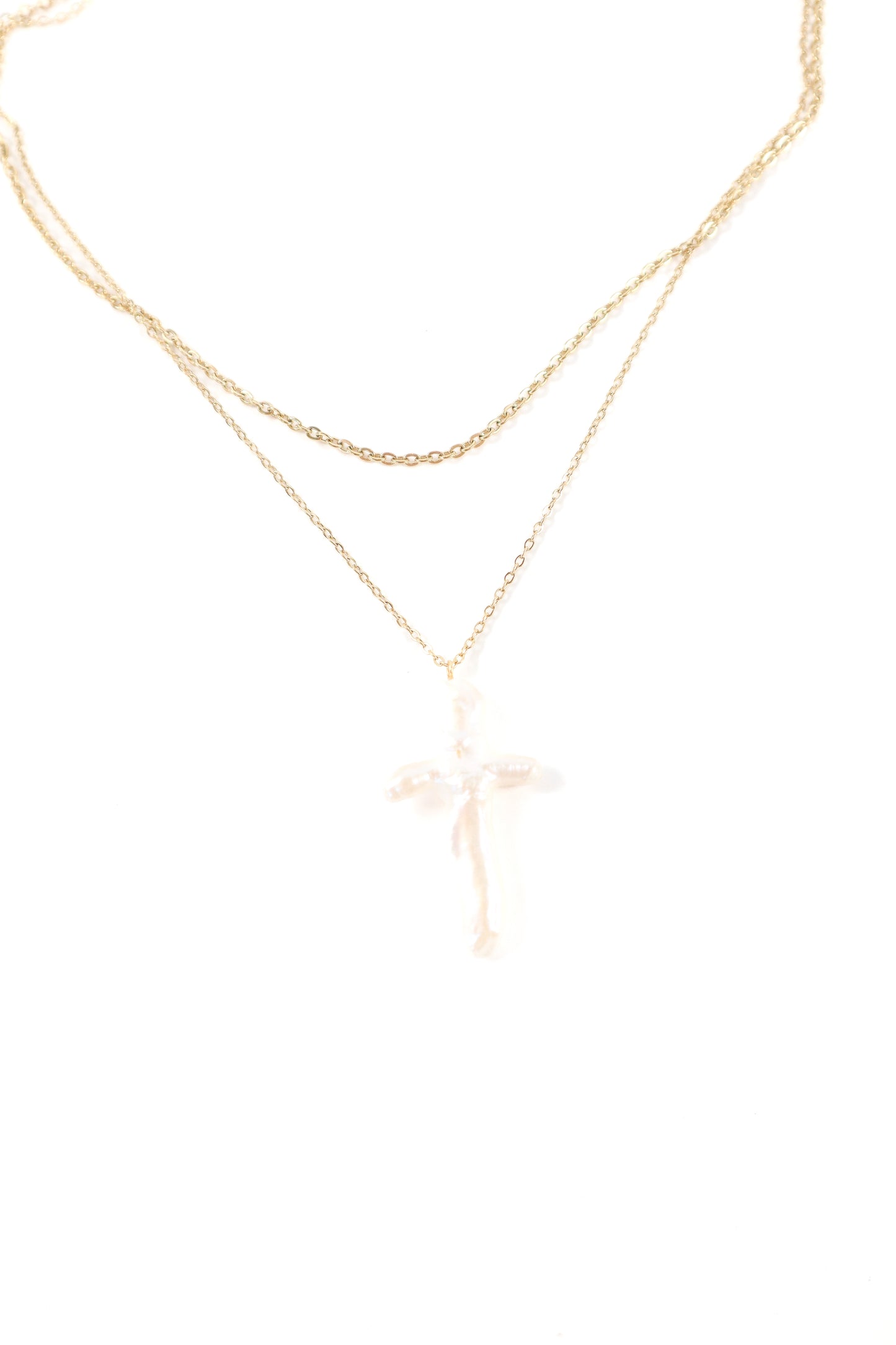 Delicate double-layer gold necklace featuring a polished cross pendant on fine gold chains.