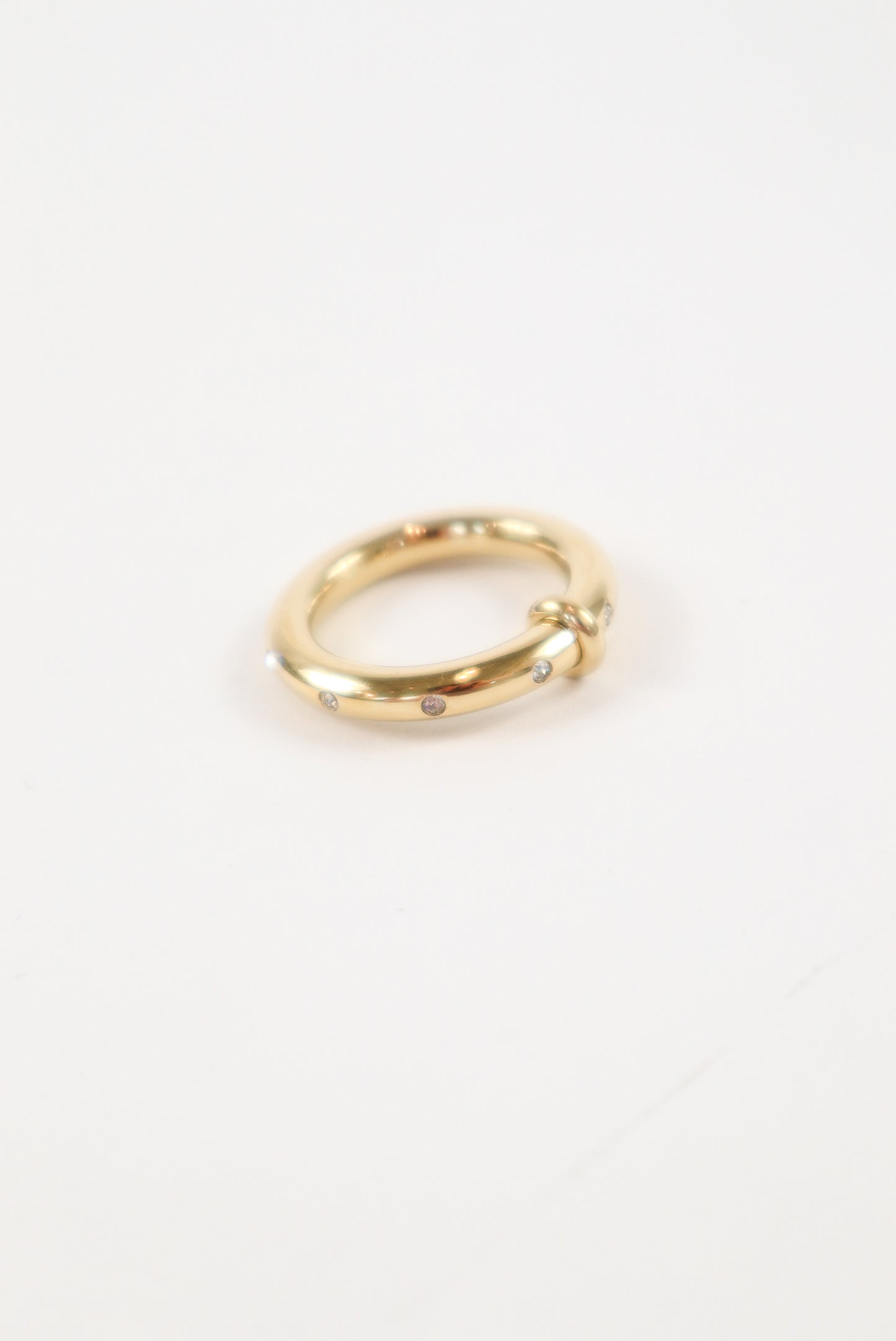 14K yellow gold knot ring with small round diamond accents on a polished minimalist band
