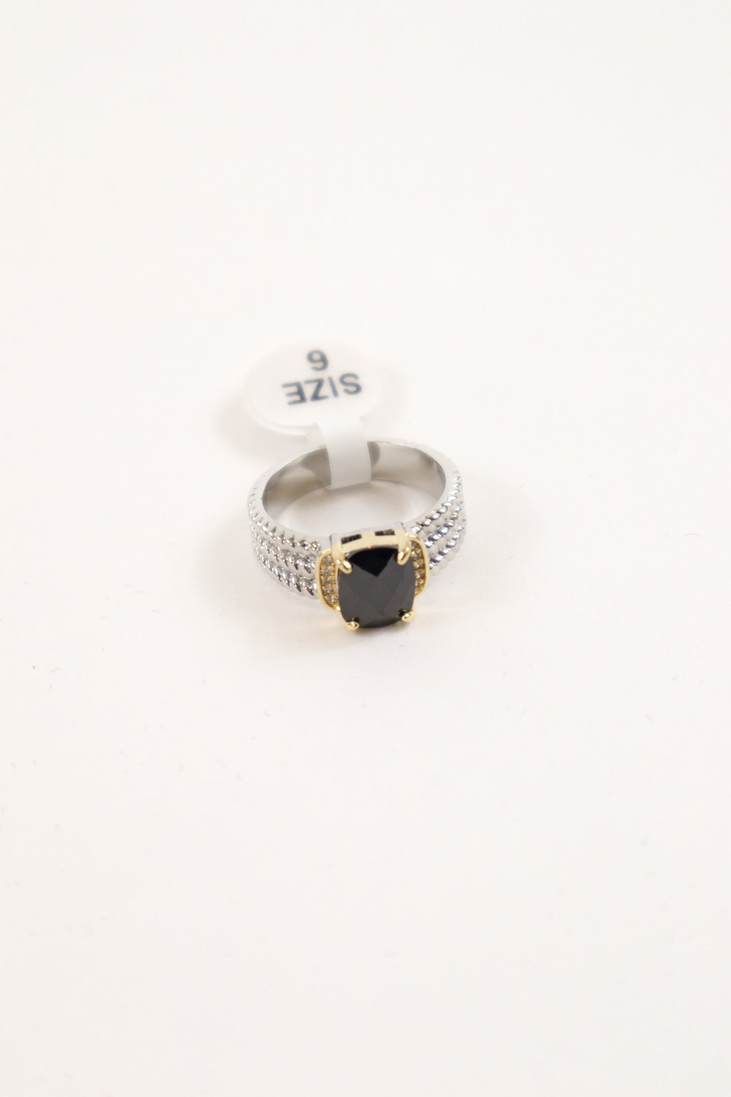 Mixed metal statement ring with black cushion-cut stone, gold prongs, and pavé crystal silver band