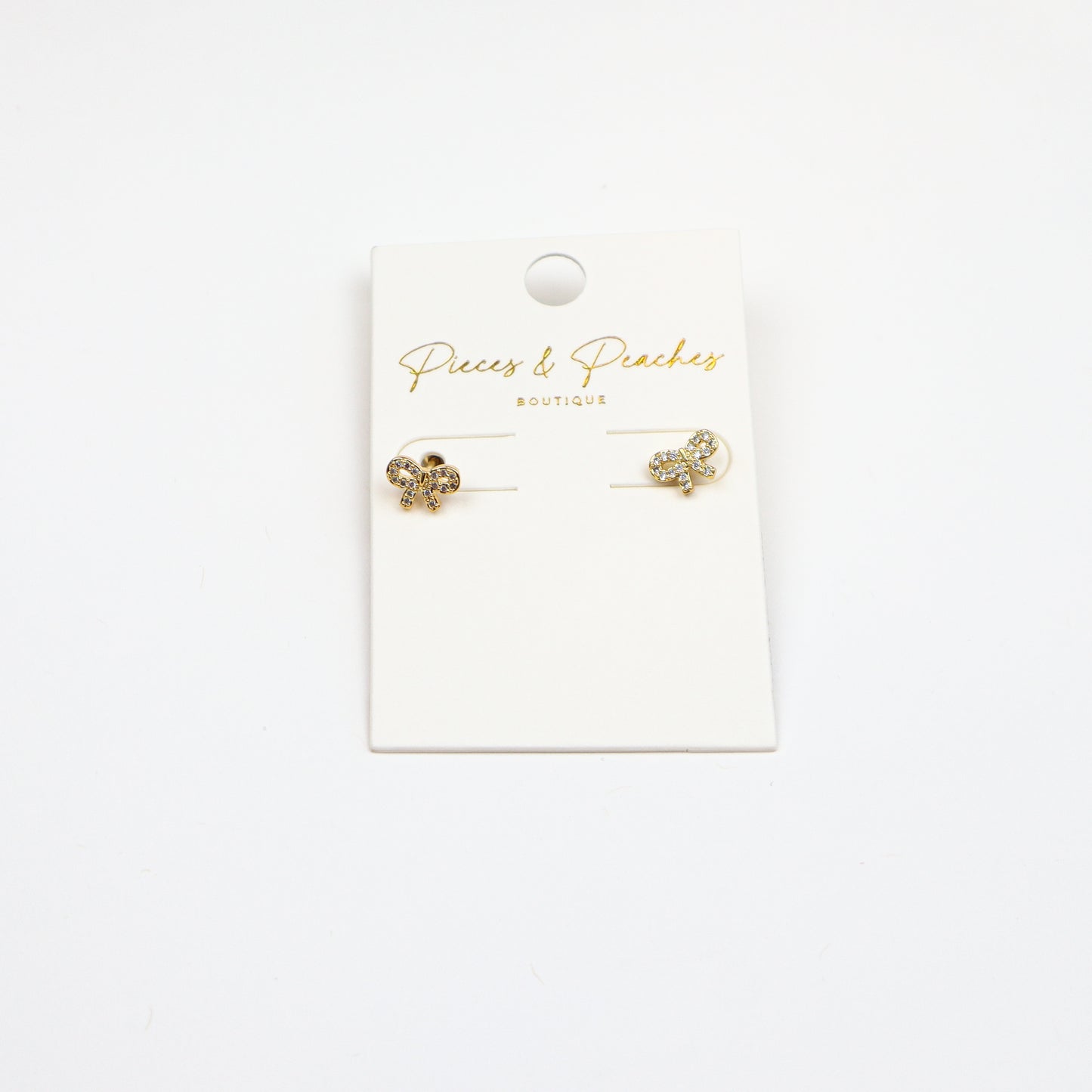 Dainty gold bow stud earrings with cubic zirconia accents