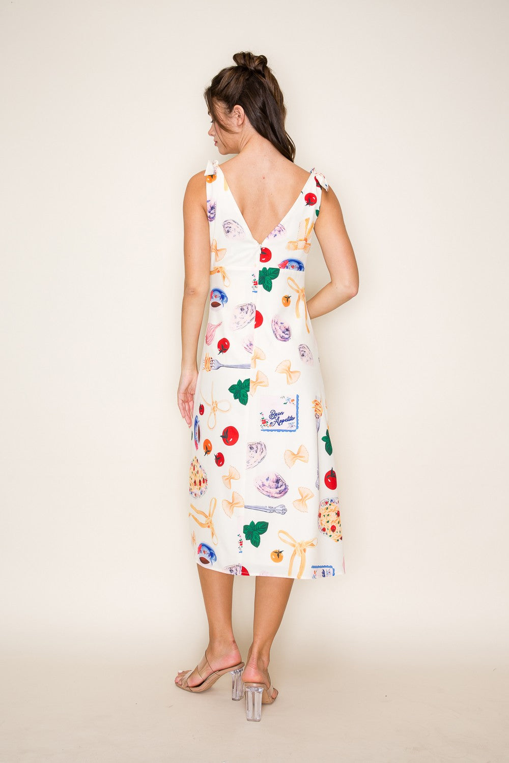 Mediterranean-inspired midi dress with bow-tied shoulders and a breezy slit.