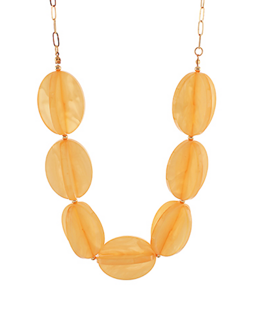 Short, chunky statement necklace featuring large, smooth, translucent light yellow beads strung together.