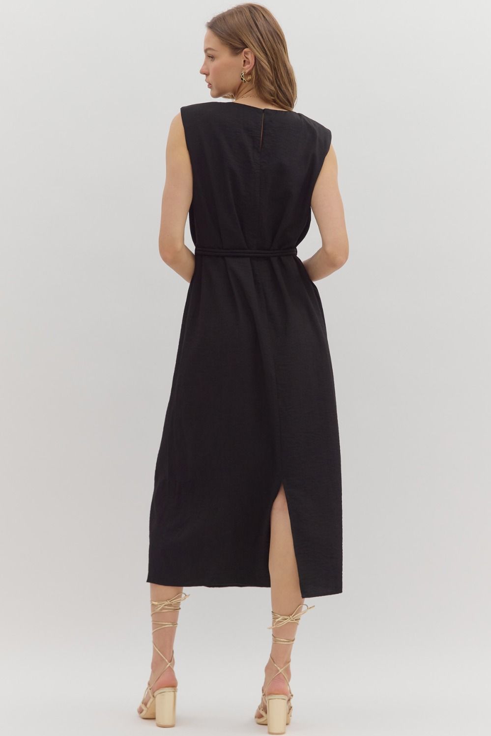 Solid muscle shoulder slit hem midi dress featuring embellished gold accent fastner belt. Single button keyhole closure at back neck. Lined. Woven. Non-sheer. Lightweight.