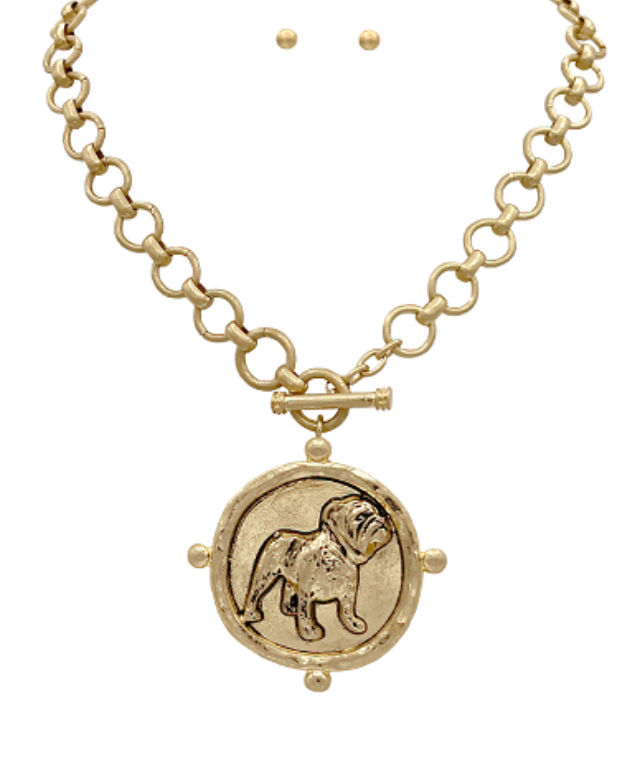 A bold gold-toned medallion necklace featuring an intricately detailed bulldog pendant on a chunky chain with a toggle clasp.