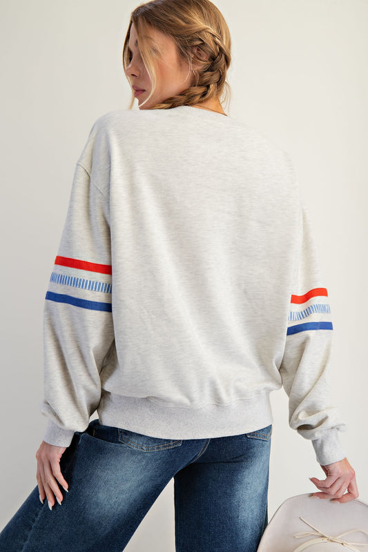 The Claribel Pullover features bold USA patch lettering, colorblock stripes, and a comfy relaxed fit—perfect for effortless patriotic style.