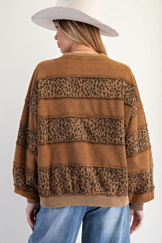 The Darla Pullover blends cozy terry comfort with bold animal print, stripe paneling, and lace-up neckline ties.
