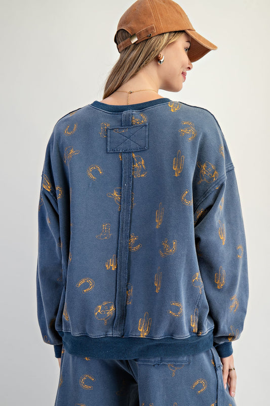 The Hollis Pullover features a mineral-washed western print, exposed seam details, and a relaxed crew neck fit—your new off-duty essential.
