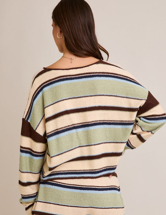 The Ingrid Sweater features bold stripes and a dramatic deep V-neckline in a cropped silhouette—designed for elevated casual layering.