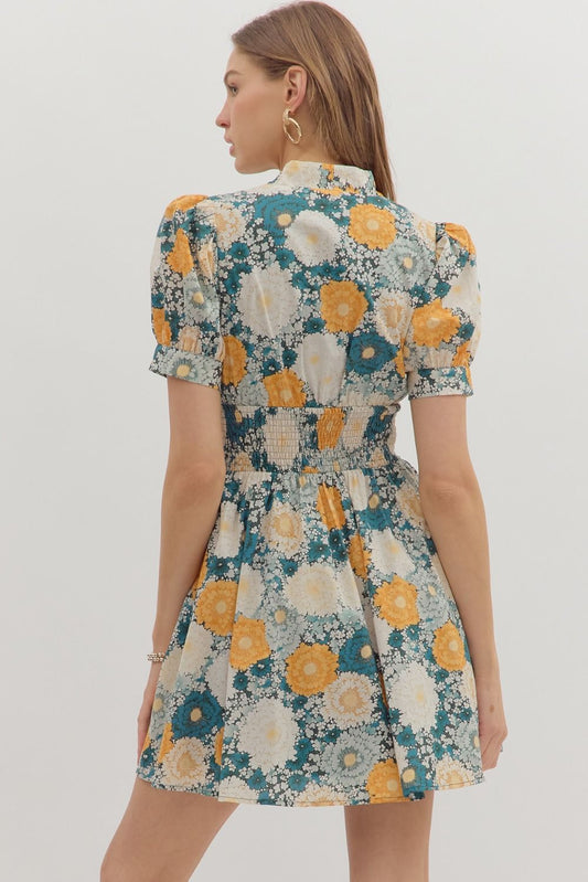 The Veda Floral Smocked Mini Dress features a romantic print, puff sleeves, and a zip-front design for easy, flattering everyday wear.