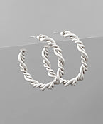 Twisted rope hoop earrings in gold and silver tones, featuring a sculpted rope-textured design for a modern and elegant statement look