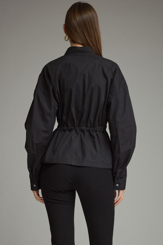 A polished 100% cotton long sleeve top featuring a sophisticated high neckline, adjustable drawstring waist, and button cuffs.