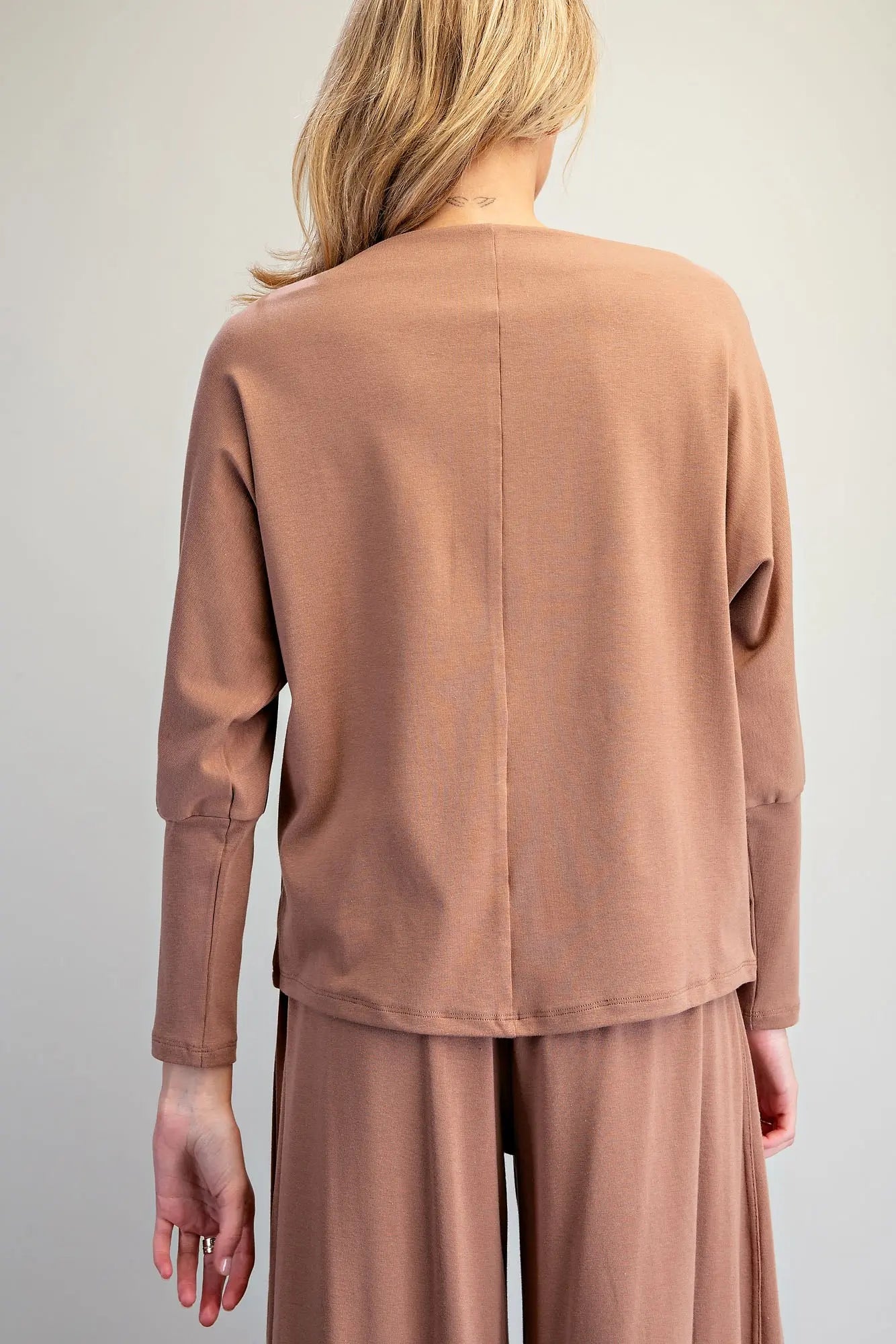 An effortlessly chic knit top featuring an elegant boat neckline, relaxed dolman sleeves, and elongated cuffs for timeless everyday style