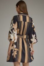 A feminine printed mini dress featuring dramatic balloon sleeves, a classic shirt collar, button-front closure, and a flattering self-tie waist.