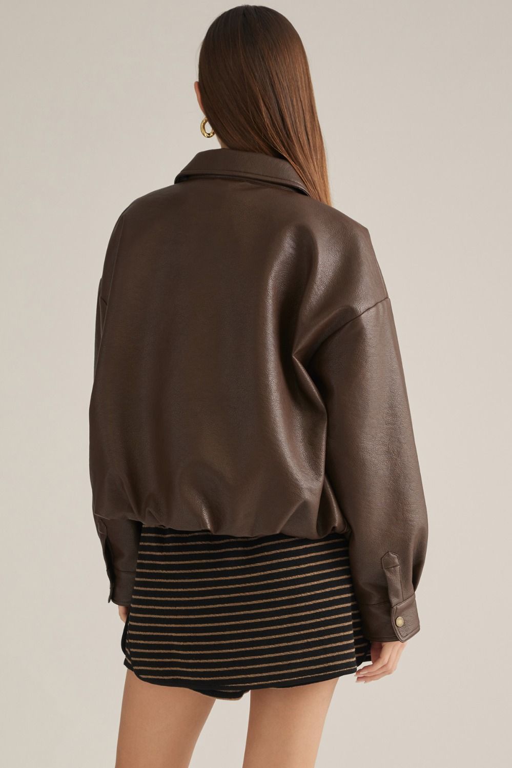 A sleek faux leather jacket featuring a classic shirt collar,bubble hem, front zipper, button cuffs, and practical side pockets for polished everyday style.
