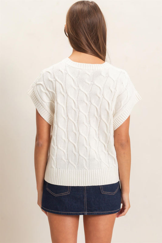 A timeless cable knit sweater featuring a classic crew neckline and cap sleeves for an effortlessly polished look you'll wear year-round.
