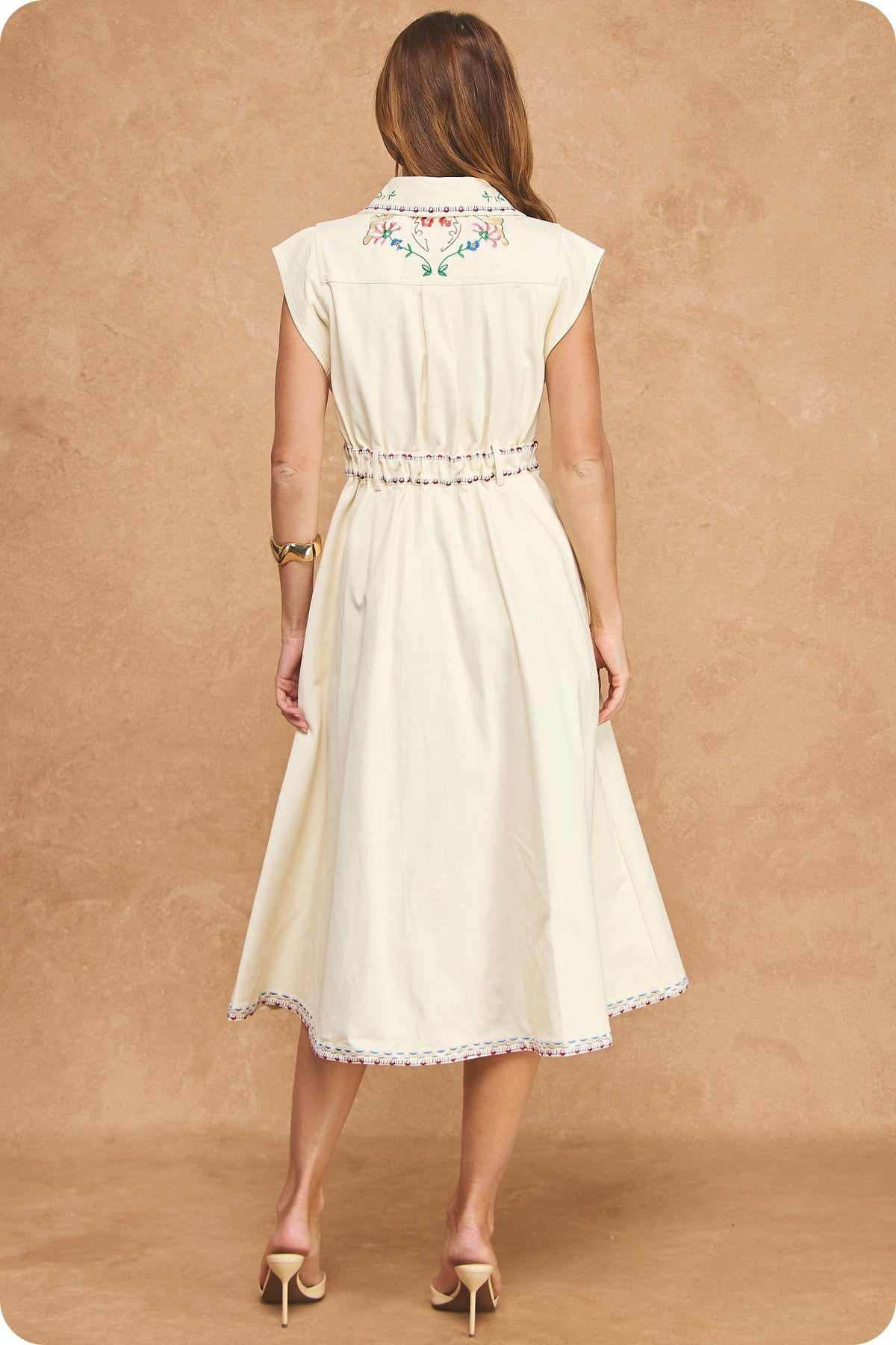 An effortlessly elegant cotton twill midi shirt dress featuring delicate embroidery, a button-front design, and a timeless off-white finish.
