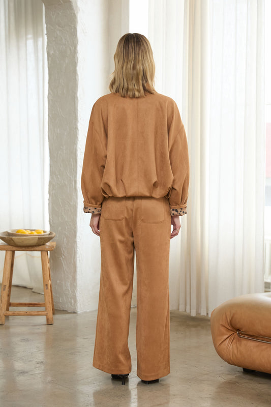A contemporary faux suede jacket featuring a sculptural bubble hem and structured silhouette for an elevated, fashion-forward look.