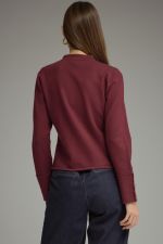 A polished knit jacket featuring a classic round neckline, zip-front closure, decorative buttons, and refined button details at the cuffs.