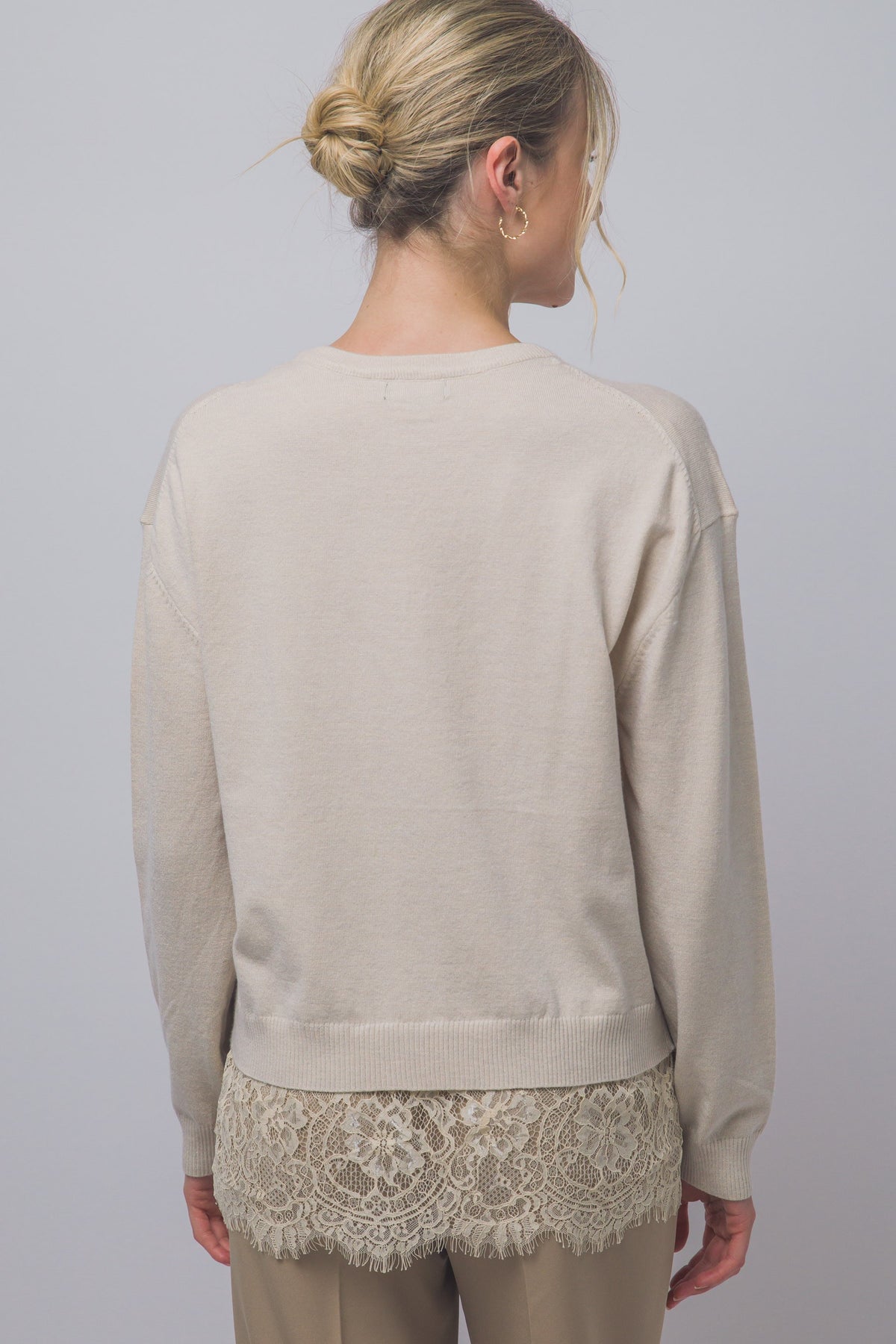 Cozy meets feminine in this oversized V-neck sweater, featuring long sleeves and a delicate lace-trim hem for a romantic, effortlessly chic look.