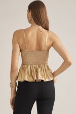 A feminine sleeveless peplum top featuring adjustable shoulder straps, elegant front pleating, and a smocked back for a flattering fit.